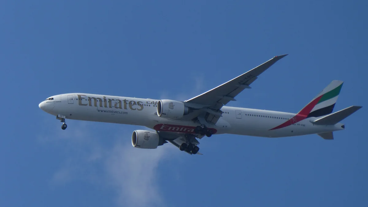 Emirates aircraft flying against a blue sky